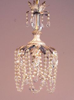 a crystal chandelier hanging from the ceiling in a room with pink walls and flooring