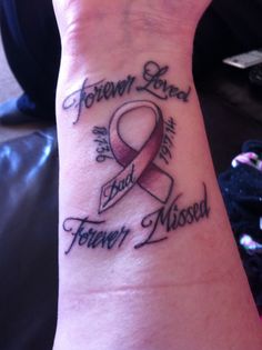 a wrist tattoo with the words forever loved and a pink ribbon