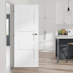 a white kitchen with an island and stools