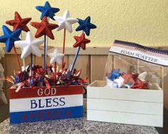 an american flag centerpiece with red, white and blue stars in it next to a sign that says god bless america