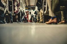 several people are sitting on the bus with their feet up