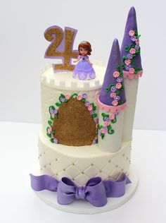 a white cake with purple decorations and a princess figure on top