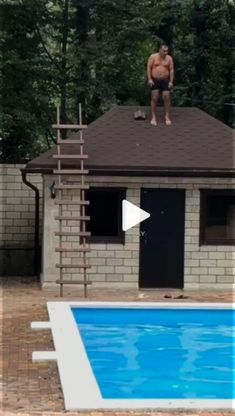 a man standing on the roof of a house next to a pool with a ladder