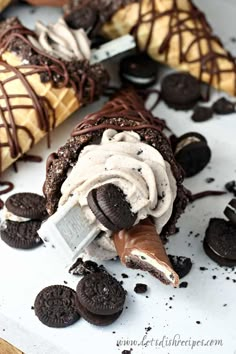 an ice cream sundae with oreo cookies and chocolate waffle cones on the side