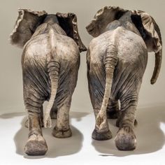 two statues of elephants walking next to each other