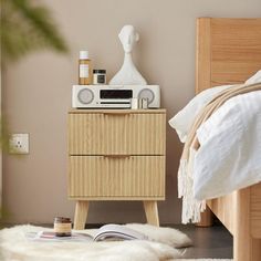 a bedroom with a bed, nightstand and radio on the side table in front of it