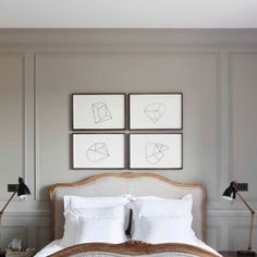 a bed with white linens and pillows in a bedroom next to two framed pictures on the wall