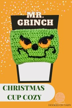 a crocheted christmas cup cozy with an image of a grin face on it