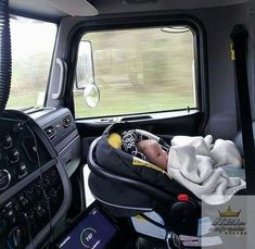 a baby in a car seat inside the back of a truck