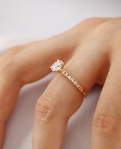 a woman's hand with a diamond ring on top of her finger and an engagement band