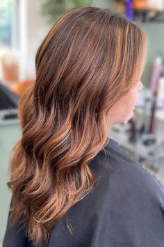 Woman with brown hair and soft strawberry blonde highlights.