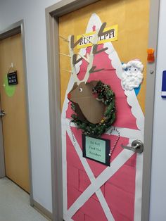 a door decorated to look like a farm animal with a wreath on it's head