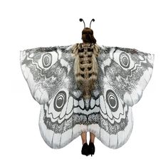 a woman is standing in front of a large butterfly