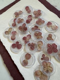 a bunch of small pink flowers sitting on top of a white tablecloth covered floor