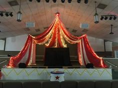 the stage is decorated with red and white draping, lights, and curtains