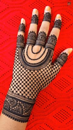 a woman's hand with hennap on top of red tablecloths