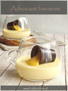 two glasses filled with pudding on top of a wooden table