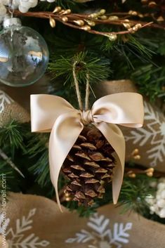 a pine cone ornament hanging from a christmas tree