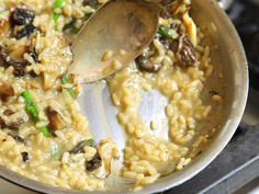 a spoon is being used to stir rice with mushrooms