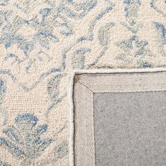 the corner of an area rug with blue and white designs on it's edges