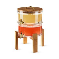 a wooden stand with a glass container on it and a lid in the shape of a barrel