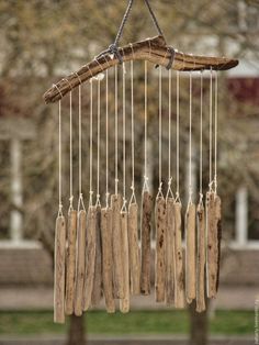 a wind chime made out of driftwood hanging from a tree