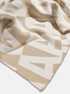 an image of a blanket that is on top of a white surface with brown and beige patterns