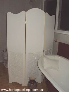 a bathroom with two tall white dividers next to a bathtub