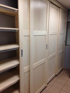 an empty walk in closet with shelves and cupboards