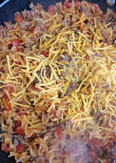 a skillet filled with pasta and meat covered in cheese