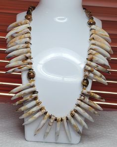 This necklace has Natural Yellow Tiger Eye gemstone beads with acrylic imitation Ivory Tusk pendant, and resin wolf tooth charm beads. This is a beautiful caramel color with a silvery stainless steel chain attached that will keep its beautiful shine. The smooth tooth beads are 1.5" and the necklace is 21" long. This necklace is versatile and the tooths can be worn either way as in the photos. I have attached a 1" antique silver clasp for convenience and easy access to put on and take off. Wolf Tooth, Tusk Pendant, Tusk Necklace, Wolf Teeth, Tooth Charm, Tiger Eye Gemstone, Charm Beads, Tigers Eye Gemstone, Caramel Color