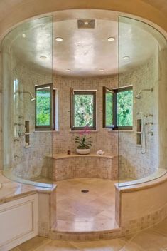 a large bathroom with a walk in shower next to a sink and tub area, along with two windows