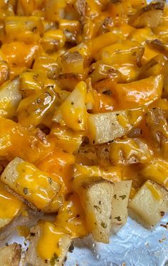 some potatoes and cheese are on top of tin foil, ready to be cooked in the oven