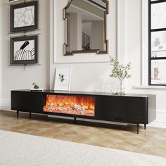 a living room with a fireplace in the center and pictures on the wall above it