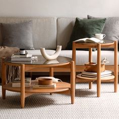 a living room with a couch, coffee table and books on the tables in front of it