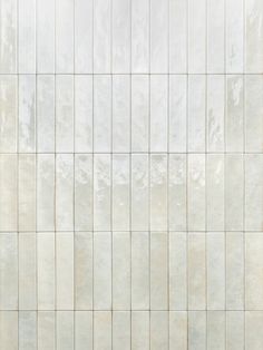 a white tiled wall with no one standing on the floor or sitting in front of it