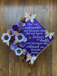 a purple and gold graduation cap with flowers on it that reads she was not simply beautiful, not because she did not have