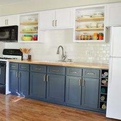 a kitchen with blue cabinets and white walls