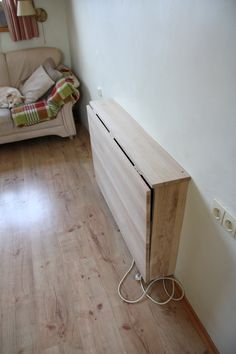 a wooden cabinet sitting on top of a hard wood floor next to a white couch