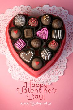 a heart shaped box filled with chocolates on top of a doily