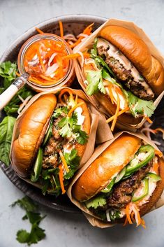 four burgers with lettuce, tomato sauce and cheese on them sitting on a plate