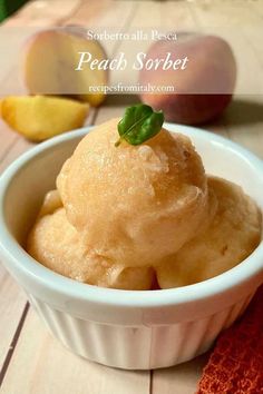 a bowl filled with ice cream next to an apple on top of a wooden table