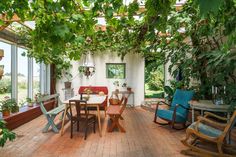 an enclosed patio with chairs, tables and potted plants