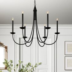 a black chandelier hanging from a ceiling in a living room with white walls