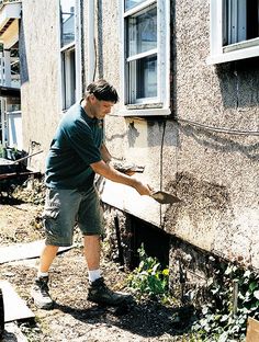 a man is painting the side of a house