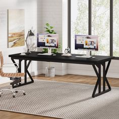 a computer desk with two monitors and a chair in front of it on top of a rug