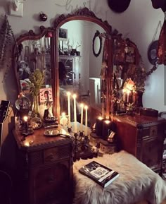 a living room filled with lots of furniture and candles in front of a large mirror