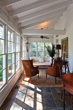 a living room with lots of windows and furniture