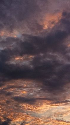 an airplane is flying in the sky at sunset or dawn with some clouds above it