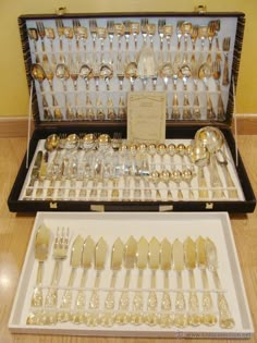 an assortment of silverware is on display in a case with its matching trays